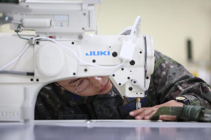 공정화물의장대는 전군에서 유일하게 낙하산 개조 임무를 수행하고 있다. 특수재봉기로 낙하산을 개조하는 모습.