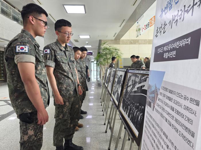 육군50보병사단 화랑여단이 진행한 특별사진전에서 장병들이 사진을 관람하고 있다.