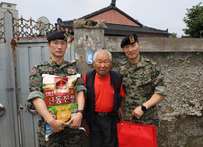 육군특전사 천마부대 부사관단이 국가유공자 전우돕기 행사에서 6·25전쟁 참전용사에게 쌀을 전달한 뒤 기념사진을 찍고 있다. 부대 제공