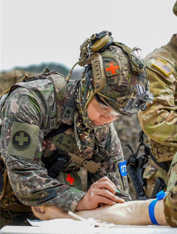 국군대전병원 치과 군의관 김형기 육군소령이 ‘전술적 현장처치’ 평가에서 약물 및 수액을 투여하기 위해 정맥로를 확보하고 있다.