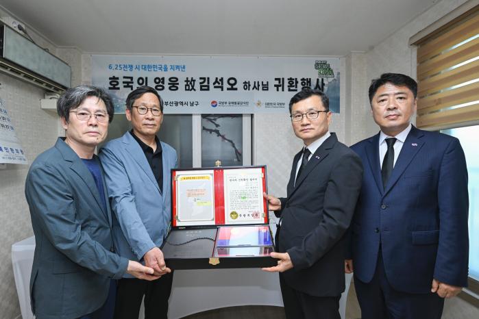 이근원(오른쪽 둘째) 국방부 유해발굴감식단장이 2일 호국의 영웅 귀환 행사에서 고 김석오 하사의 유가족에게 호국의 얼 함을 전달하고 있다. 부대 제공