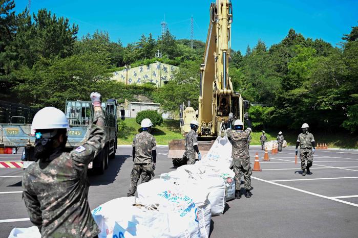 3일 해군진해기지사령부가 주관한 재난대응훈련 참가자들이 대형 포대로 유도배수로를 설치하고 있다. 사진 제공=남호 중사