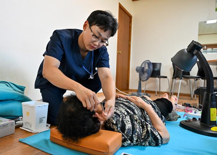 공군18전투비행단 항공의무대대 의무요원이 지역주민에게 한방시술 의료봉사를 하고 있다. 사진 제공=장형석 하사
