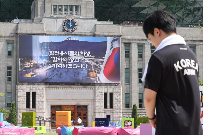 현충일인 지난달 6일 오전 10시 서울 중구 서울도서관 앞에서 한 시민이 사이렌이 울리자 묵념하고 있다. 연합뉴스