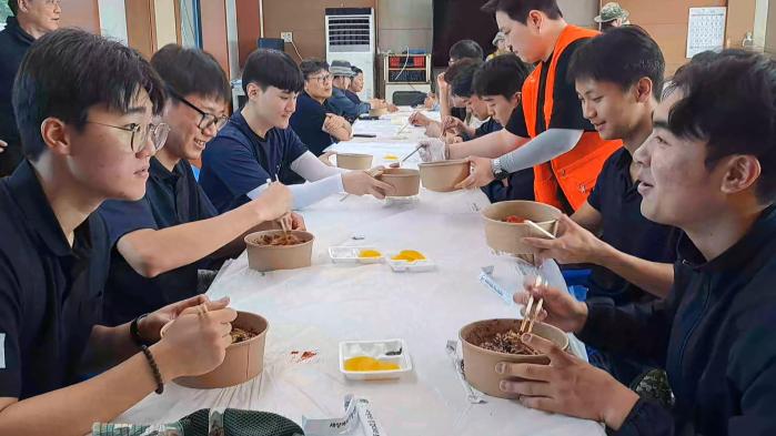 해군3함대 안마도 기지에 근무하는 장병들이 함대 주임원사단과 사랑의 징검다리 봉사단이 요리해 준 짜장면을 먹고 있다. 부대 제공
