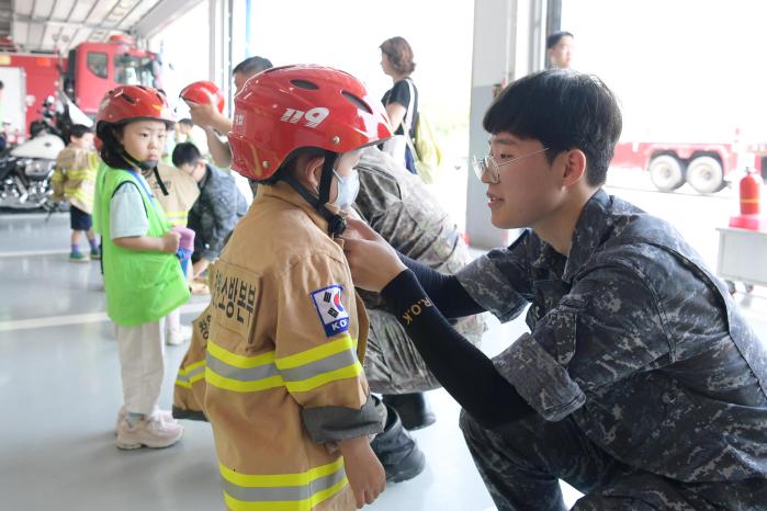 해군진해기지사령부 장병이 안보현장 견학차 부대를 찾은 덕산·바다마을 해군어린이집 원생에게 방화복을 입혀주고 있다. 부대 제공