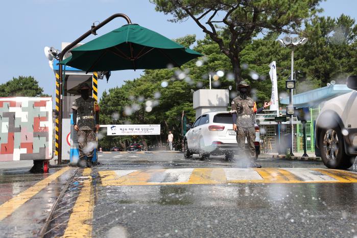 연일 불볕더위가 이어지는 가운데 10일 해군진해기지사령부 기지방어대대 장병들이 진해기지 1정문에서 대형 그늘막과 에어컨이 설치된 환경에서 근무 중이다. 정문 인근 도로에서는 스프링클러가 시원한 물줄기를 내뿜고 있다. 조종원 기자