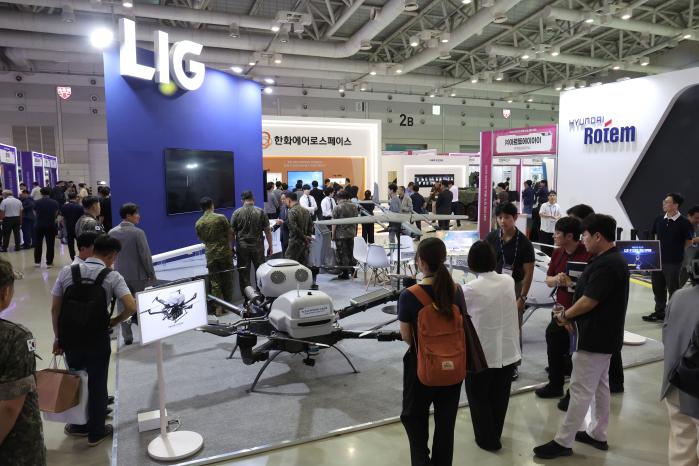 관람객과 관계자들이 전시된 다양한 제품들을 살펴보고 있다.