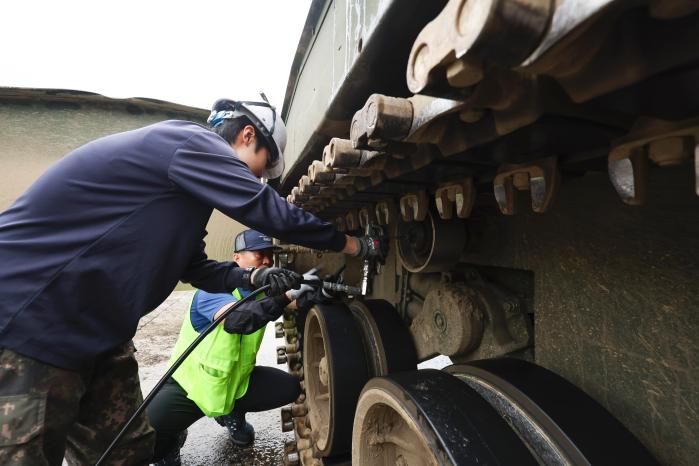 현수 장치를 세밀하게 점검하고 있다.