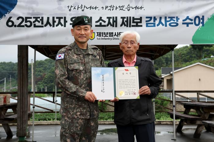 양진혁(왼쪽) 1보병사단장이 이옹에게 감사장을 전달한 후 기념촬영하고 있다.