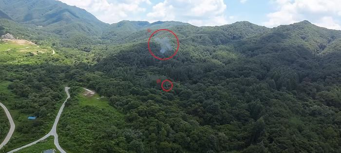 FPV 자폭 드론의 타격으로 연기가 발생한 대공표적기(①번 빨간 원)가 잔해(②번 빨간 원)와 함께 추락하고 있다. 부대 제공