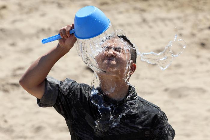 한 참가자가 얼굴에 찬물을 끼얹으며 더위를 식히고 있다.