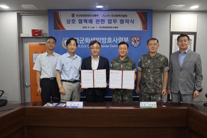 전종율(오른쪽 셋째) 국군화생방방호사령관과 김주현(왼쪽 셋째) 민군협력진흥원장 등 양 기관 주요 직위자들이 지난 1일 업무협약 체결식에서 협약서를 들어 보이고 있다. 부대 제공