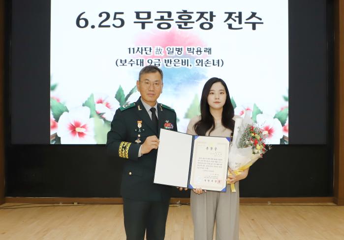 김광석(왼쪽) 육군35보병사단장이 지난달 31일 고(故) 박용래 상병의 화랑무공훈장을 외손녀인 반은비 군무주무관에게 전수한 뒤 기념사진을 찍고 있다. 부대 제공