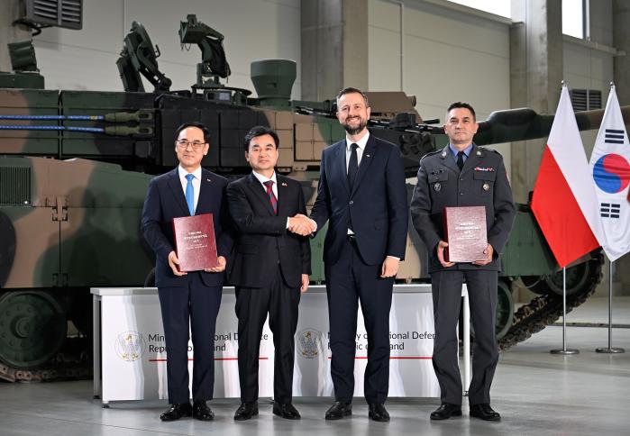 안규백(왼쪽 둘째) 국방부 장관이 K2 전차 2차 이행계약 서명식에서 브와디스와프 코시니아크카미시 폴란드 국방장관과 악수하고 있다. 왼쪽부터 이용배 현대로템 사장, 안 장관, 코시니아크카미시 장관, 아르투르 쿱텔 폴란드 군비청장. 국방부 제공