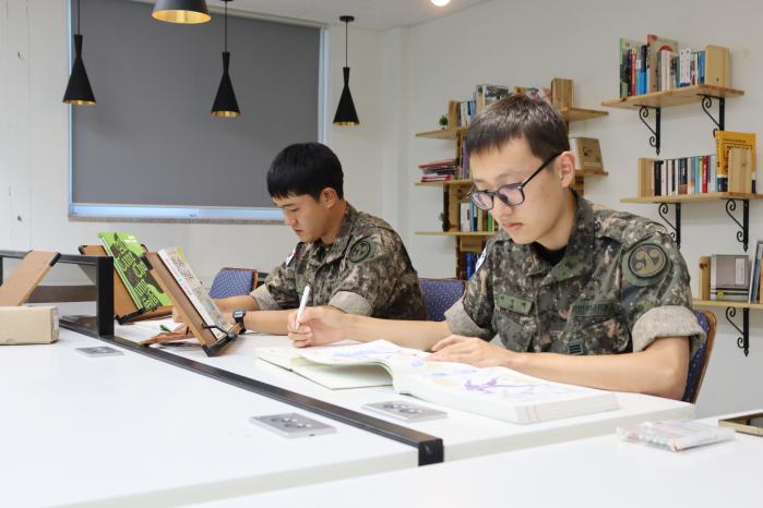 고재휘(왼쪽)·이민재 상병이 일과 후 시간을 이용해 학생들을 가르칠 준비를 하고 있다.