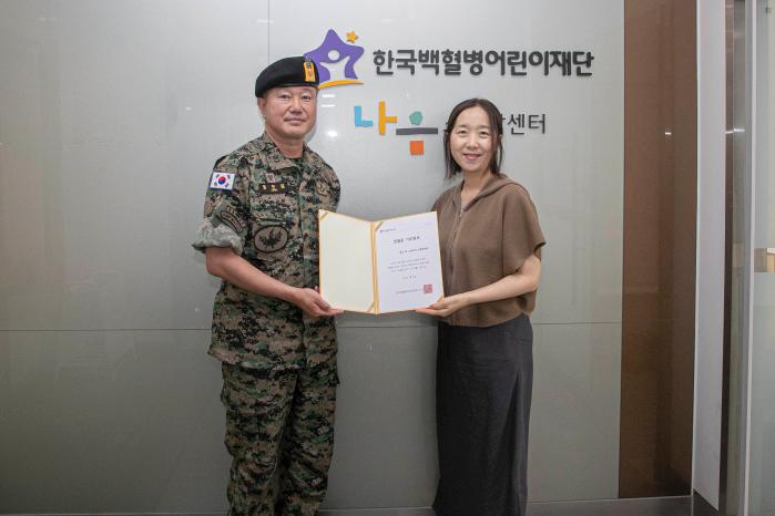 육군특전사 황금박쥐부대 버팔로대대 정헌문(왼쪽) 주임원사가 한국백혈병어린이재단에 헌혈증을 기부한 후 받은 기부증서를 들고 기념촬영하고 있다. 사진 제공=임재전 상사