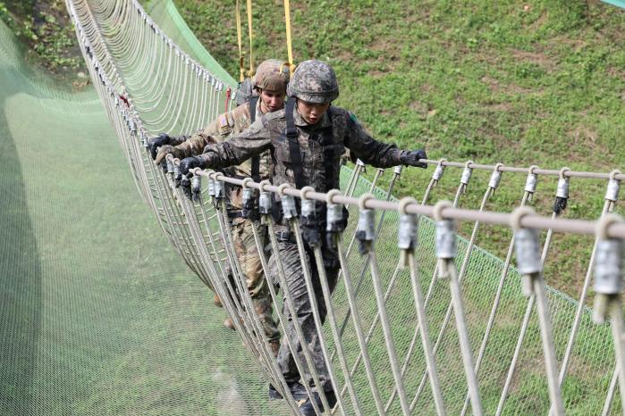 한미 육군 학생군사교육단(ROTC) 후보생들이 지난 8일 육군학생군사학교에서 열린 동반 유격훈련에서 산악 장애물의 하나인 ‘한 줄 다리’(위 사진)와 ‘세 줄 다리’(아래 사진)를 하고 있다.