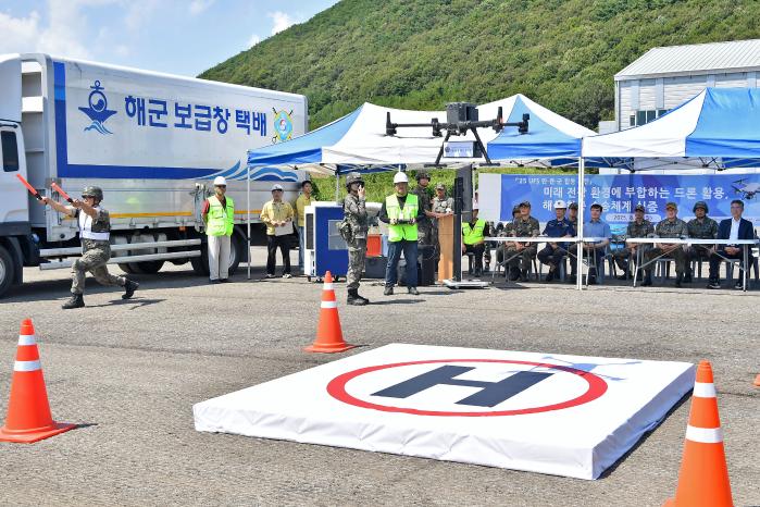 해군군수사령부를 비롯한 민·관·군 훈련 관계관들이 25일 무인체계 활용 도서기지 군수품 수송훈련 중 군수품을 드론에 실어 도서기지로 수송하고 있다. 사진 제공=배준호 상사