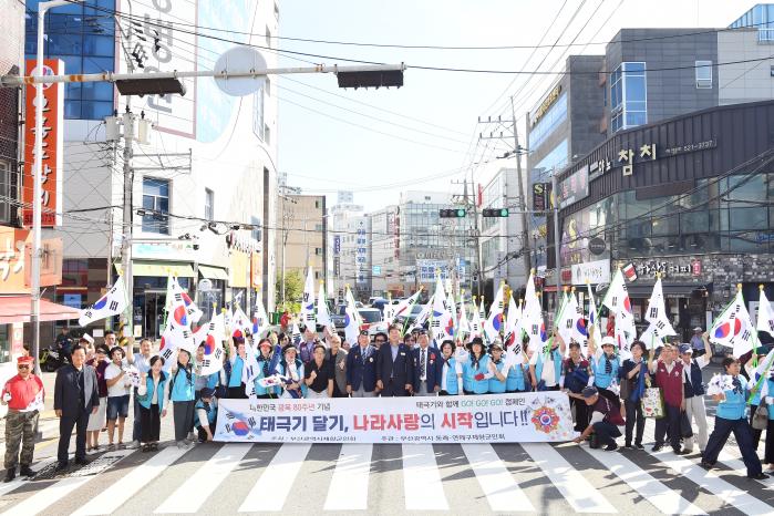 부산시향군 회원들이 지난 14일 동래구 서원시장에서 전개한 태극기 달기 및 나눔 활동을 마친 뒤 시장 입구에서 기념촬영을 하고 있다. 부산시향군 제공