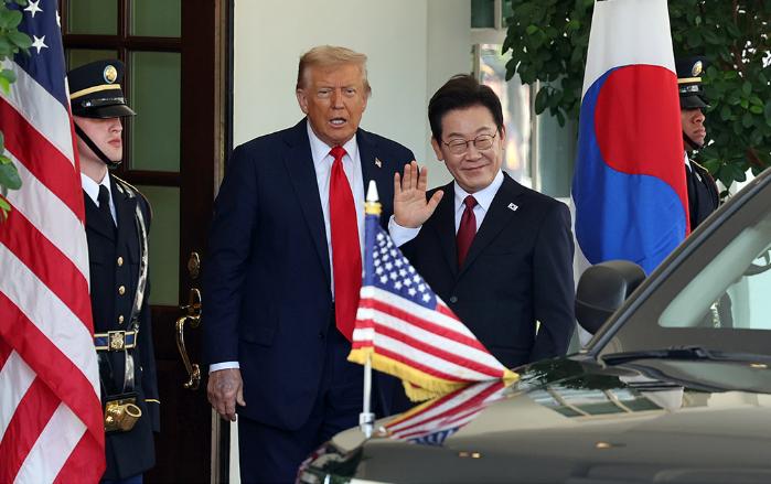 이재명 대통령이 25일(현지시간) 미국 워싱턴DC 백악관에서 영접나온 도널드 트럼프 미국 대통령과 기자들을 바라보며 손을 흔들고 있다. 연합뉴스