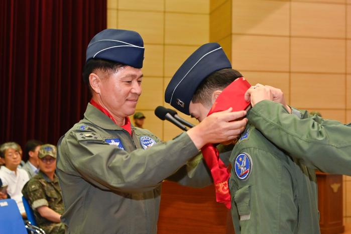 이영수 공군참모총장이 27일 공군1전투비행단에서 열린 ‘24-3차 고등비행 교육 과정 수료식’에서 신임 조종사에게 빨간 마후라를 매주고 있다. 사진 제공=장석원 중사