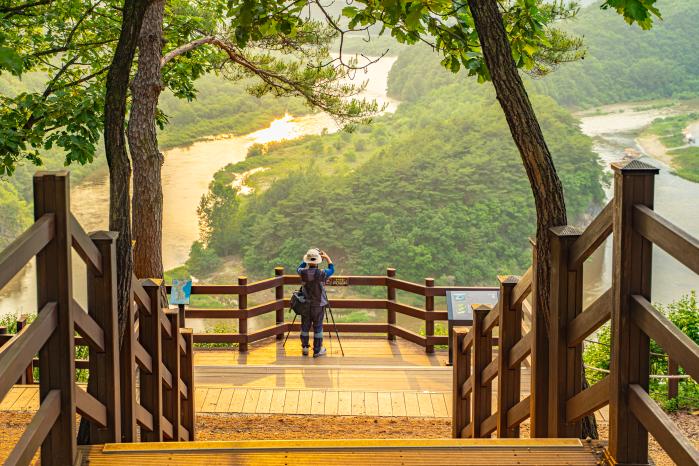 강원 영월군 동강의 휘황찬란한 물줄기로 빚은 한반도 형태의 지형. 한 관광객이 카메라에 한반도 모습을 담고 있다. 사진=필자 제공