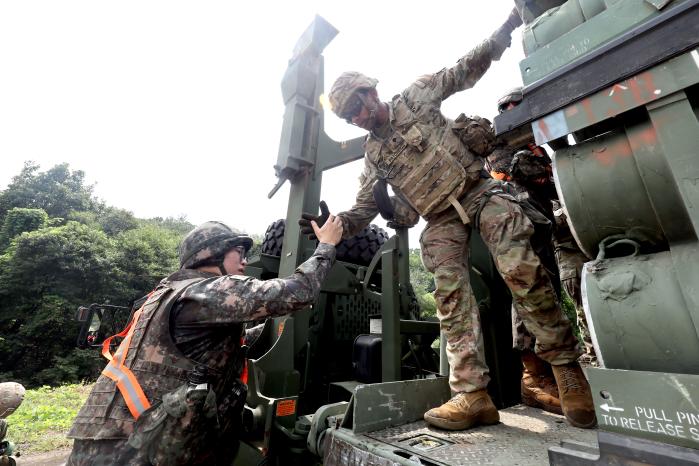 지난 25일 육군1군수지원여단에서 열린 전시 대화력전 대비 탄약 보급훈련에서 한미 장병들이 힘을 합쳐 PLS 차량에 오르고 있다. 조종원 기자