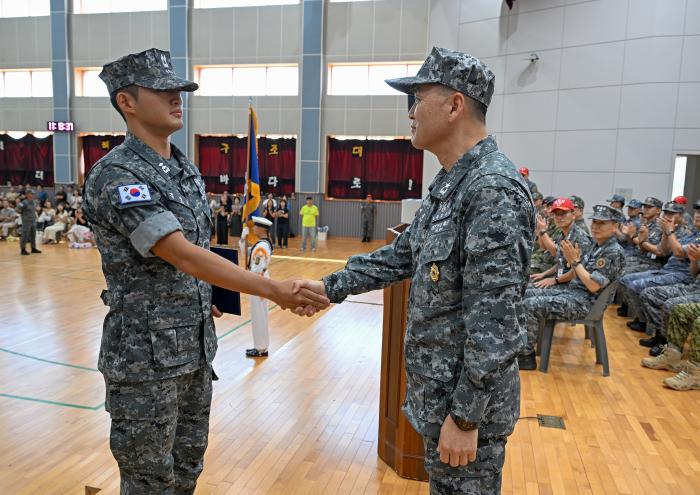 지난달 30일 해군특수전전단 해난구조전대(SSU) 실내체육관에서 열린 해난구조 기본과정 10기 수료식에서 이종이(오른쪽) 특수전전단장이 대표 수료생 김영윤 중위에게 상장을 수여한 뒤 악수하고 있다. 부대 제공
