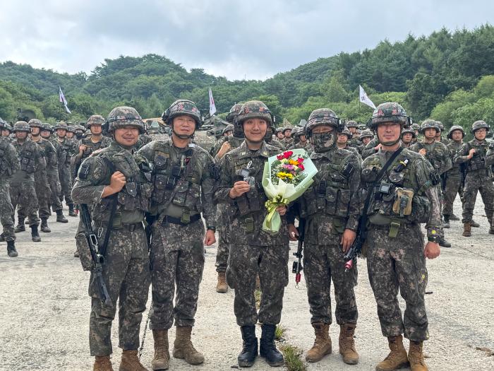 육군1기갑여단 진격대대가 육군과학화전투훈련단(KCTC) 훈련장에서 개최한 권민서(앞줄 가운데) 하사 현지 임관식에서 오승준(왼쪽 둘째) 대대장과 부대 주요 직위자들이 기념사진을 찍고 있다. 부대 제공