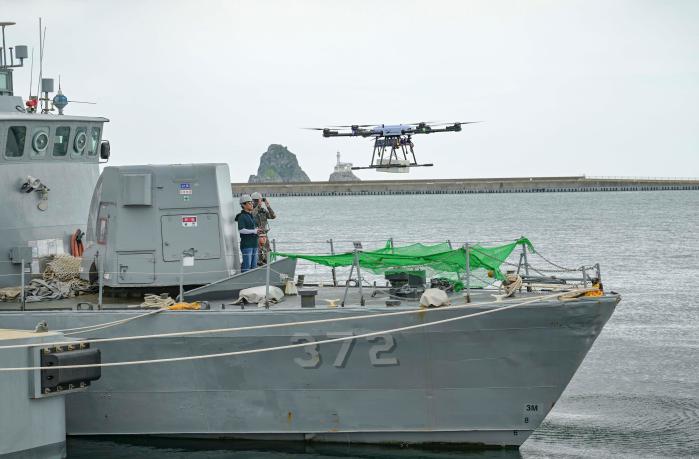 해군작전사령부가 2일 부산작전기지에서 전개한 드론 활용 함정 의무·군수 물자 보급훈련에서 국군대전병원 드론팀이 드론을 활용해 의무 물자 및 수리 부속을 고속정으로 이송하고 있다. 부대 제공