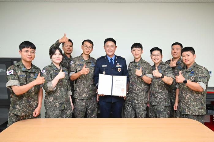 공군 최초 비파괴검사 대한민국명장에 선정된 공군19전투비행단 항공정비전대 이용우(가운데) 준위가 동료들의 축하를 받으며 기념촬영을 하고 있다. 부대 제공