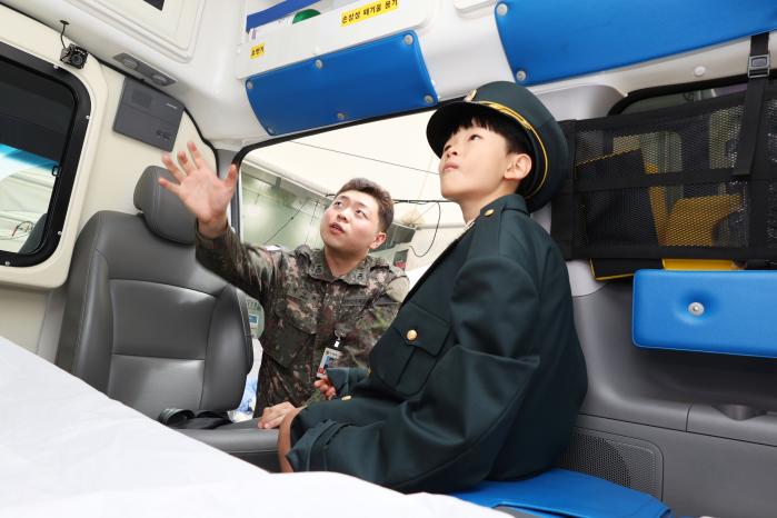 국군수도병원 박상휘 육군중위가 구급차 체험 부스를 방문한 청소년에게 차량 내부 설치 장비를 설명하고 있다. 부대 제공