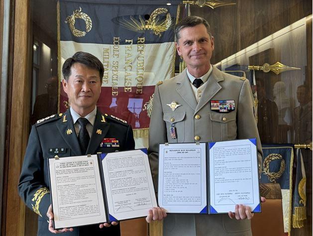 육군3사관학교 김호길(왼쪽) 교수부장과 에마뉘엘 샤피 프랑스 생시르 육군사관학교 교장이 학술·교육협력 협약을 위한 업무협약서를 들어 보이고 있다. 부대 제공