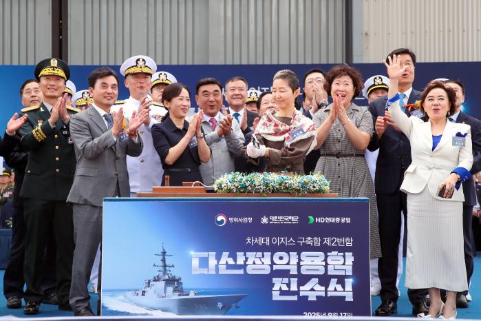 17일 울산 HD현대중공업에서 거행된 8200톤급 이지스구축함 ‘다산정약용함’ 진수식에 주빈으로 참석한 안규백 국방부 장관의 부인 심혜정(맨 앞줄 오른쪽 셋째) 여사가 손도끼로 함정과 연결된 진수줄을 절단하고 있다.