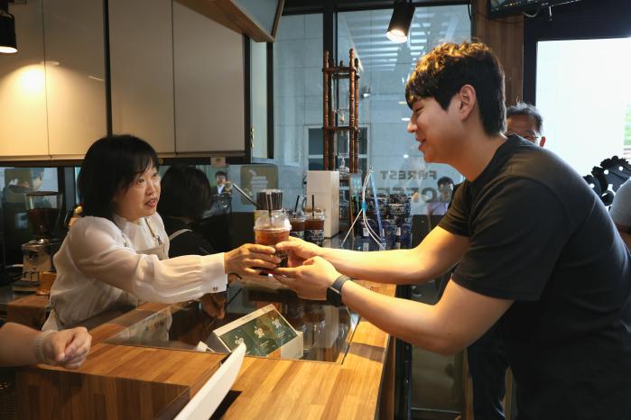 홍소영(왼쪽) 병무청장이 17일 대구 소재 나라사랑가게에서 한 병역이행자에게 음료를 전달하고 있다. 병무청 제공
