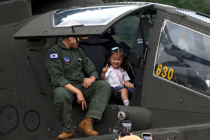 ‘2025 지상군페스티벌’ 개막식이 벌어진 17일 행사장을 찾은 한 어린이가 계룡대 활주로에서 아파치 공격헬기 탑승 체험을 하고 있는 모습.