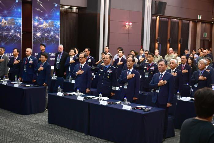 18일 공군호텔에서 손석락 공군참모총장 주관으로 열린 ‘2025 민·관·군 항공우주안전심포지엄’에서 손 총장(맨 앞줄 오른쪽 셋째)과 참석자들이 국민의례를 하고 있다. 공군 제공