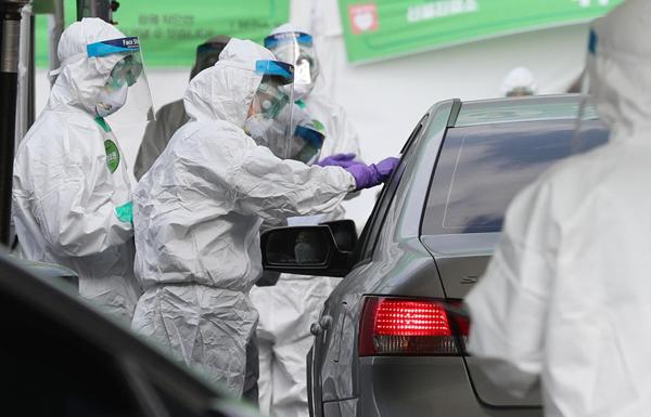 2020년 잠실종합운동장 주 경기장에 마련된 승차 검진 선별진료소에서 방호복을 입은 요원들이 코로나19 진단검사를 하고 있다. 사진=대한민국 정책브리핑