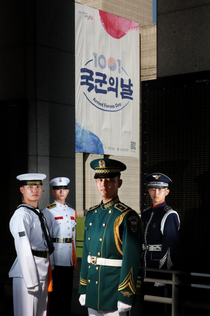 1일 건군 77주년 국군의 날을 맞아 서울 용산구 전쟁기념관에 내걸린 대형 현수막 앞에 선 국방부 근무지원단 의장대대 소속 육·해·공군 및 해병대 장병들. 김병문 기자