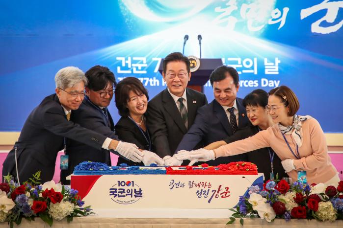 이재명(가운데) 대통령과 안규백(오른쪽 셋째) 국방부 장관이 계룡대에서 열린 국군의 날 기념오찬에서 국민대표와 함께 떡 케이크를 자르고 있다.