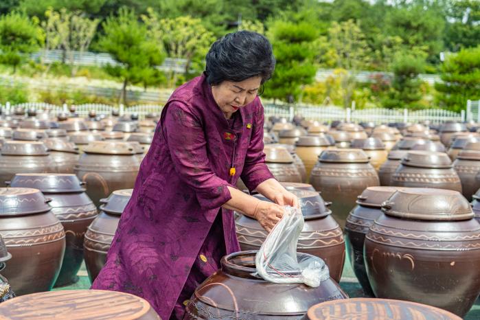 강순옥 명인이 순창 전통고추장 민속마을에서 항아리를 열어 장을 확인하고 있다. 필자 제공