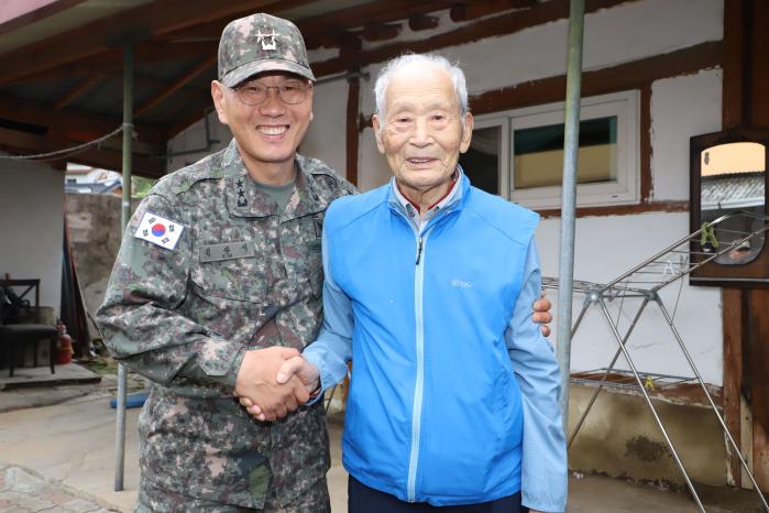 김광석(왼쪽) 육군35보병사단장이 6·25전쟁 참전용사 이한상 옹에게 선물을 전달한 뒤 기념촬영을 하고 있다.