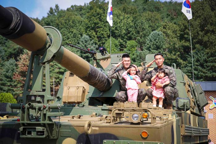 육군7포병여단 군인가족의 날 행사에서 부대 간부들이 자녀들과 K9A1 자주포 위에서 기념촬영을 하고 있다.