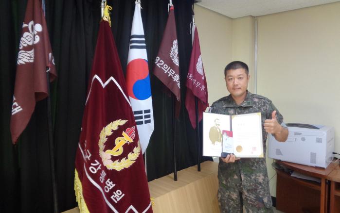 국군강릉병원 김진욱 육군상사가 헌혈유공장 ‘명예대장’을 들어 보이고 있다.