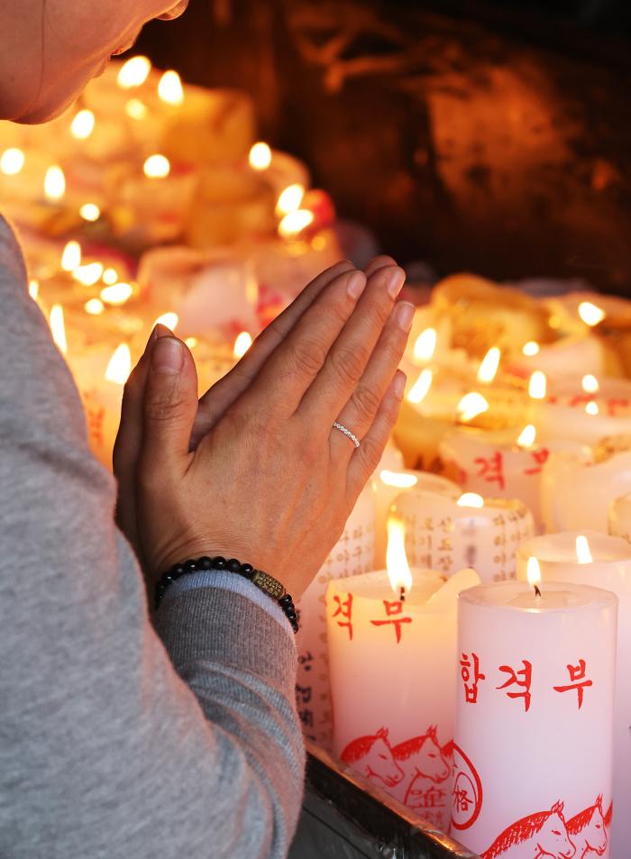 대학수학능력시험을 한 달 앞둔 13일 경기 화성시 용주사에서 학부모가 자녀의 학업 성취를 기원하는 촛불을 밝힌 후 기도하고 있다. 연합뉴스
