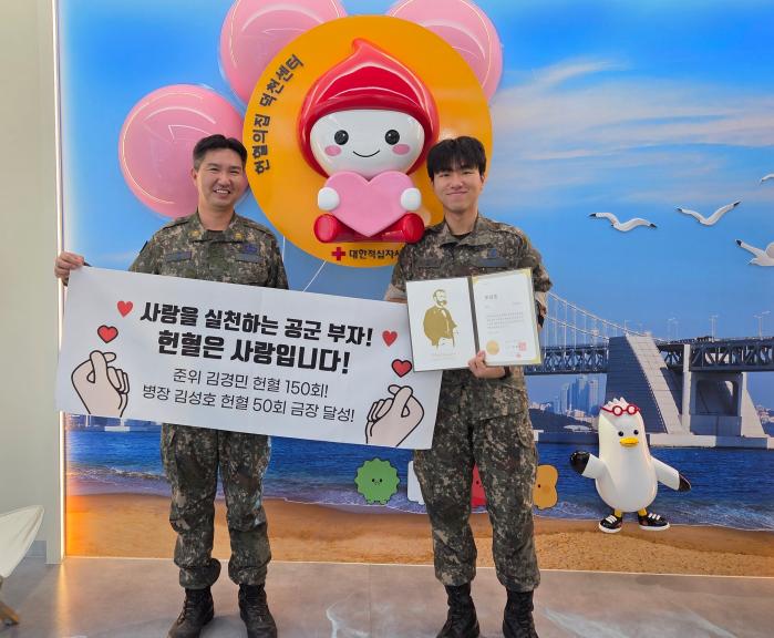 공군군수사령부 김경민(왼쪽) 준위와 아들 공군11전투비행단 김성호 병장이 13일 각각 150회, 50회 헌혈을 마친 뒤 기념촬영을 하고 있다. 부대 제공