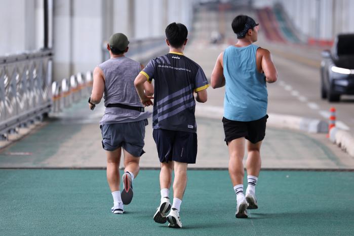 서울 시내 한낮 기온이 35도까지 오르며 폭염이 이어진 8월 서울 서초구 잠수교에서 시민들이 땀을 흘리며 뛰고 있다. 연합뉴스