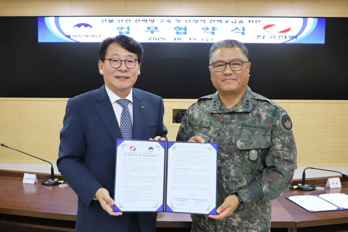 남진오(오른쪽) 21보병사단장과 송호승 한국전력 강원본부장이 15일 체결한 ‘군(軍) 배전선로 지중화사업’ 업무협약서를 들어 보이고 있다. 부대 제공