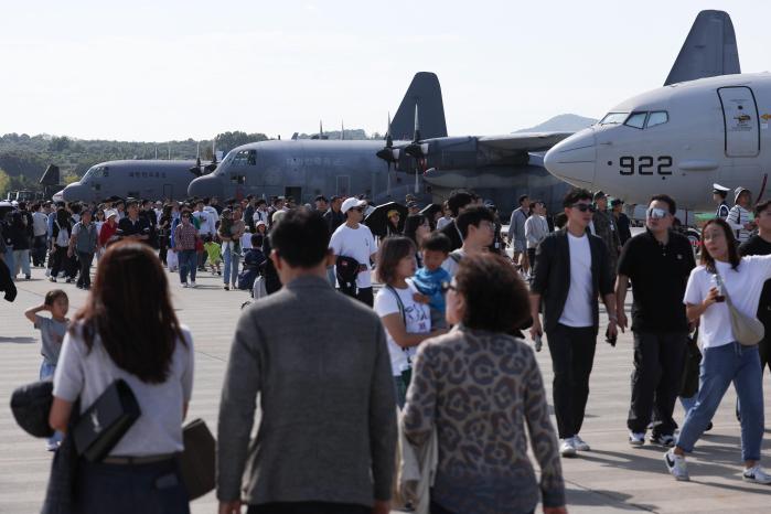 °ü¶÷°´µéÀÌ Çà»çÀå¿¡ Àü½ÃµÈ Ç×°ø±âµéÀ» µÑ·¯º¸°í ÀÖ´Ù.